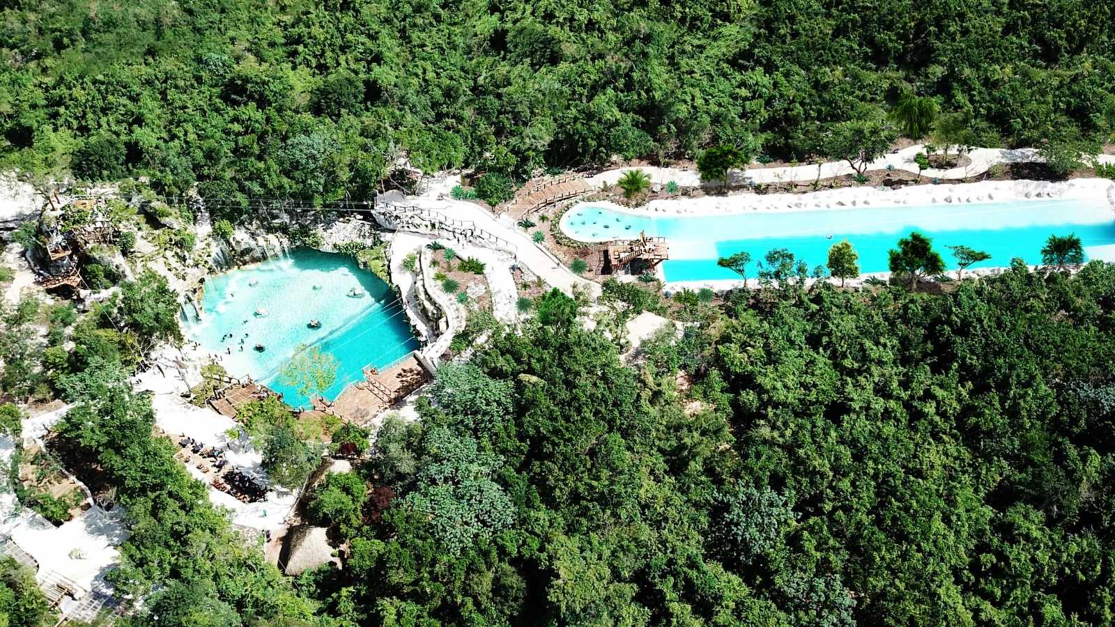 Aerial view of turquoise lagoons surrounded by forest at Scape Park, Cap Cana